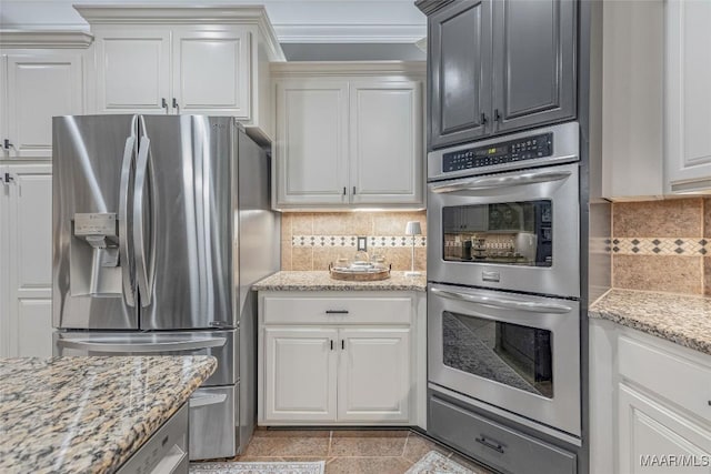378 Winding Wood Dr, Wetumpka, AL 36093 - kitchen with appliances with stainless steel finishes, tasteful backsplash, crown molding, white cabinetry, and light stone counters