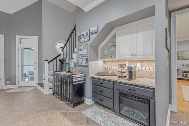 378 Winding Wood Dr, Wetumpka, AL 36093 - bar area with stairs, a towering ceiling, backsplash, and ornamental molding