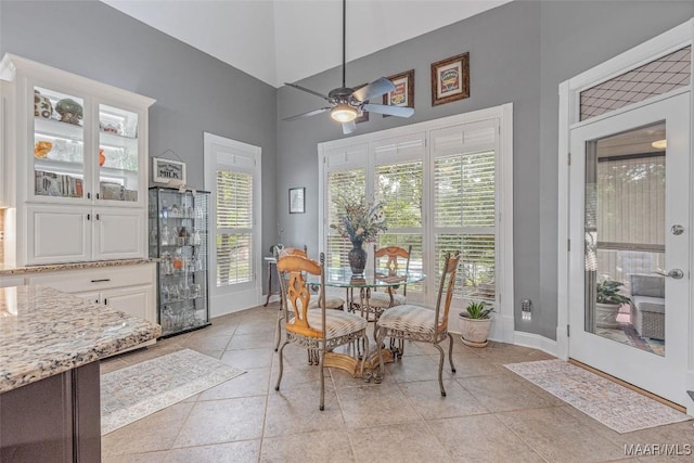 378 Winding Wood Dr, Wetumpka, AL 36093 - dining area featuring a ceiling fan, a high ceiling, and light tile patterned flooring