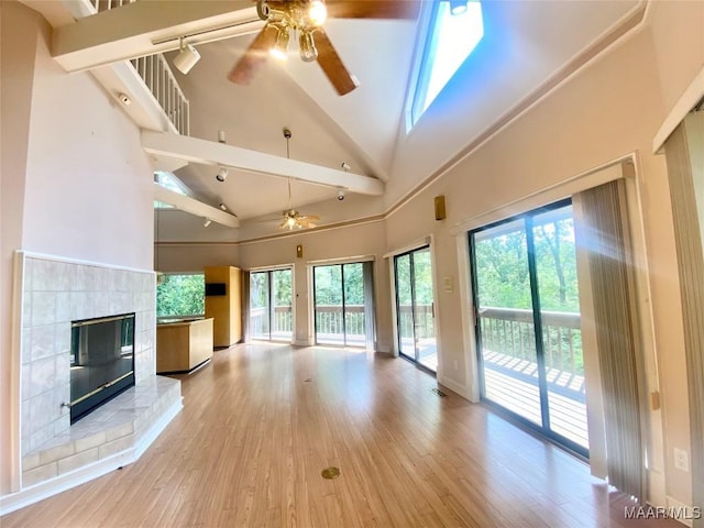 400 Millcreek Rd, Wetumpka, AL 36093 - unfurnished living room with ceiling fan, a glass covered fireplace, wood finished floors, healthy amount of natural light, and high vaulted ceiling