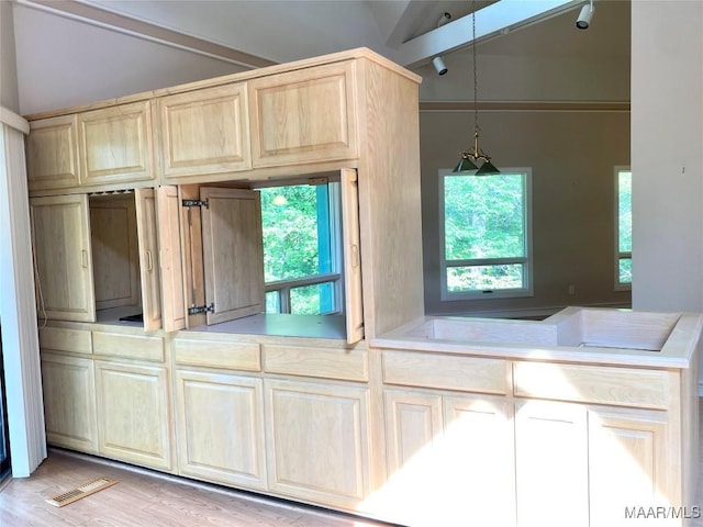 400 Millcreek Rd, Wetumpka, AL 36093 - kitchen featuring lofted ceiling, light brown cabinets, light countertops, light wood-style floors, and hanging light fixtures