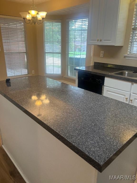 9324 Bristlecone Dr, Montgomery, AL 36117 - kitchen featuring dishwasher, white cabinets, dark countertops, and a chandelier