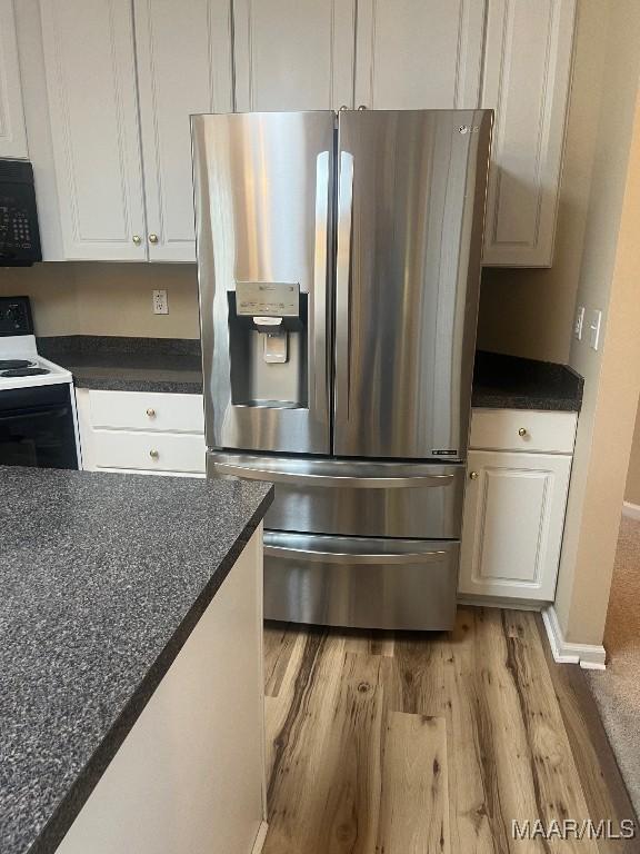 9324 Bristlecone Dr, Montgomery, AL 36117 - kitchen featuring stainless steel fridge with ice dispenser, electric range, black microwave, light wood finished floors, and dark countertops