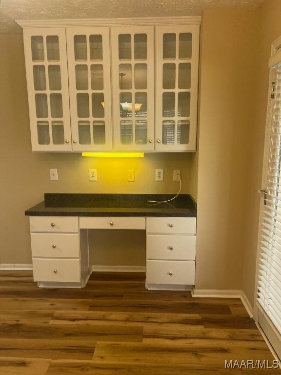 9324 Bristlecone Dr, Montgomery, AL 36117 - kitchen with built in desk, white cabinetry, dark wood-style floors, and dark countertops