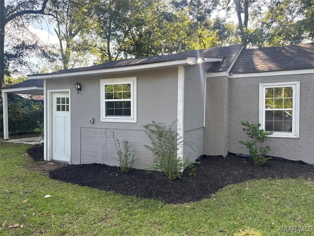 3827 Edgar D Nixon Ave, Montgomery, AL 36105 - view of side of home with stucco siding, a lawn, and roof with shingles