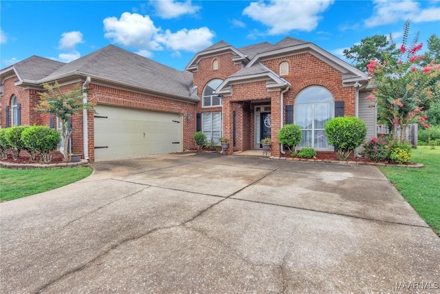 6779 Overview Dr, Montgomery, AL 36117 - traditional-style house featuring brick siding, a garage, concrete driveway, roof with shingles, and a front yard