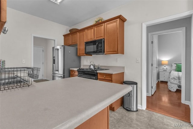 6779 Overview Dr, Montgomery, AL 36117 - kitchen featuring black appliances, light countertops, and brown cabinetry