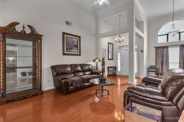 6779 Overview Dr, Montgomery, AL 36117 - living area featuring ornamental molding, a chandelier, wood finished floors, a towering ceiling, and ceiling fan