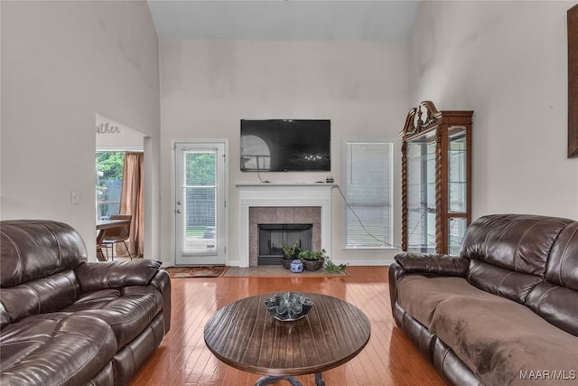 6779 Overview Dr, Montgomery, AL 36117 - living room featuring a tiled fireplace, hardwood / wood-style flooring, and a high ceiling