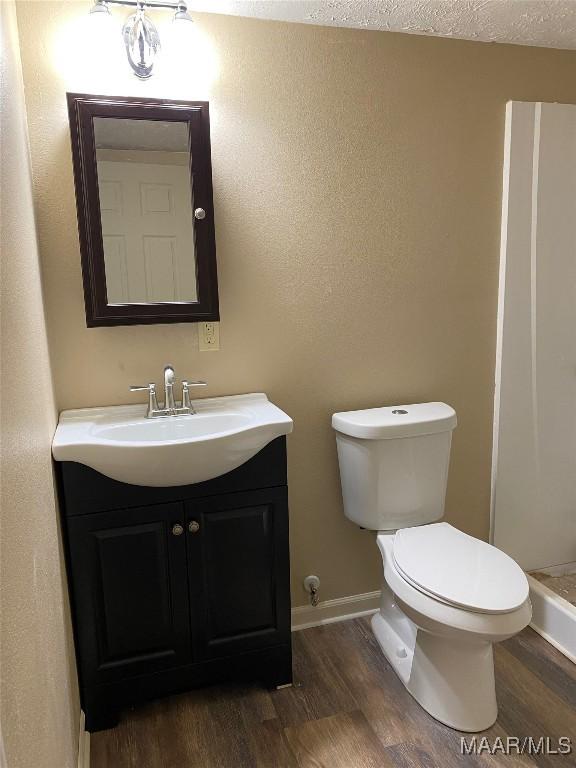 1010 New St, Tuskegee, AL 36083 - bathroom featuring wood finished floors, vanity, and a shower