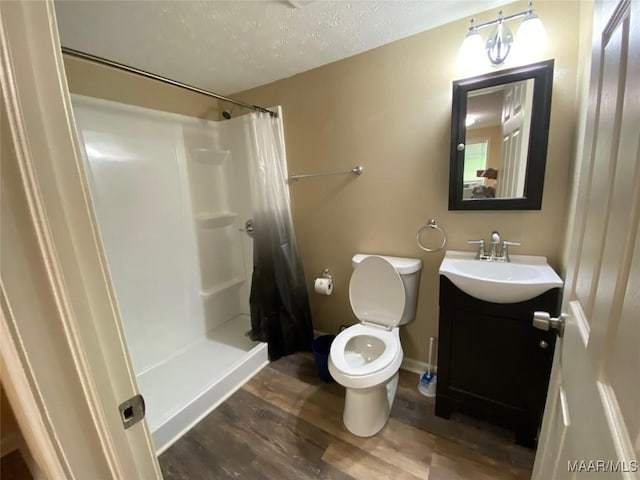 1010 New St, Tuskegee, AL 36083 - full bath featuring vanity, wood finished floors, a shower with curtain, and a textured ceiling