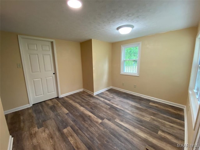 1010 New St, Tuskegee, AL 36083 - unfurnished room with dark wood-type flooring and a textured ceiling
