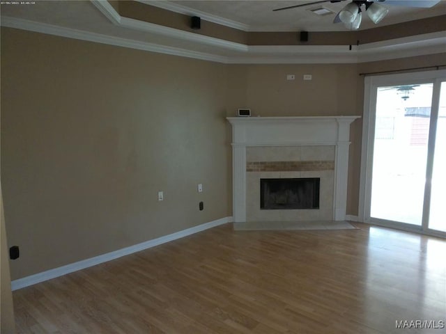 213 Foxdale Rd, Millbrook, AL 36054 - unfurnished living room featuring a raised ceiling, a ceiling fan, wood finished floors, crown molding, and a tile fireplace