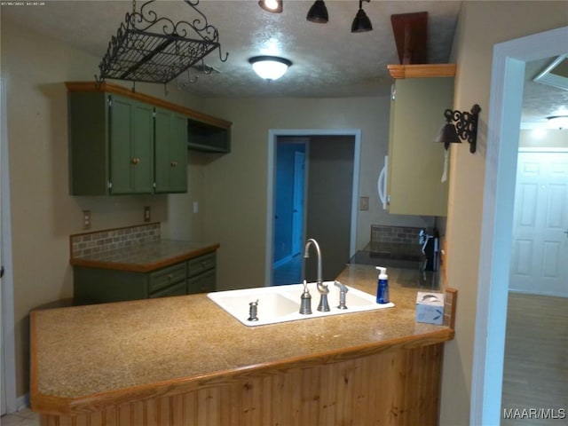 213 Foxdale Rd, Millbrook, AL 36054 - kitchen with green cabinetry, a peninsula, tasteful backsplash, and light countertops