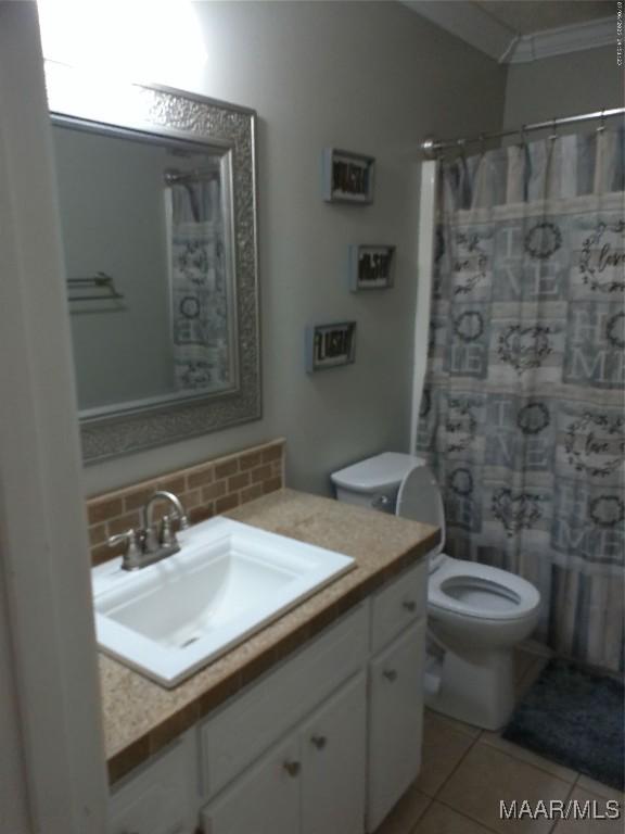 213 Foxdale Rd, Millbrook, AL 36054 - bathroom featuring decorative backsplash, vanity, tile patterned floors, ornamental molding, and a shower with shower curtain