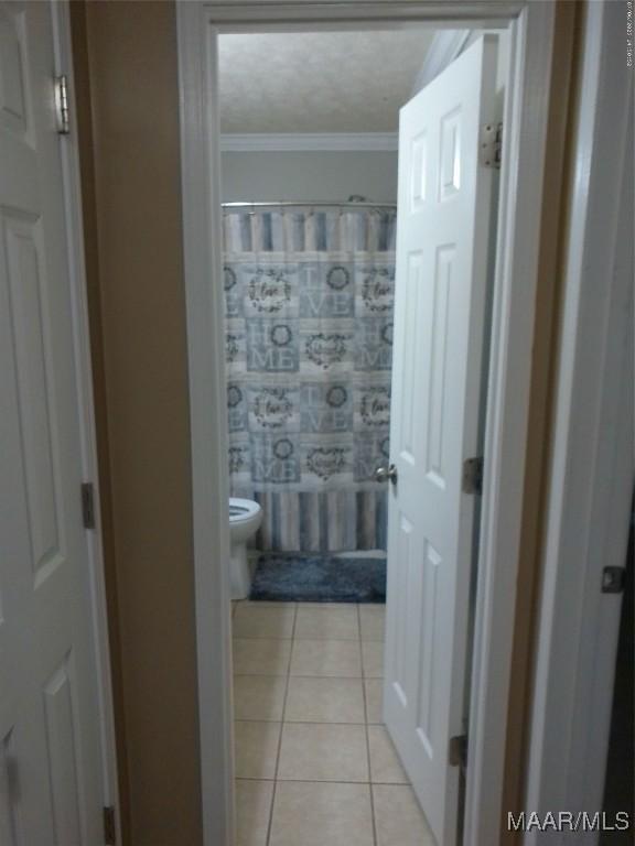 213 Foxdale Rd, Millbrook, AL 36054 - bathroom featuring tile patterned flooring, curtained shower, and crown molding