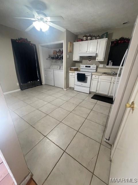 3440 Wickham Rd, Montgomery, AL 36116 - kitchen featuring white electric stove, washer and clothes dryer, light tile patterned floors, and white cabinetry