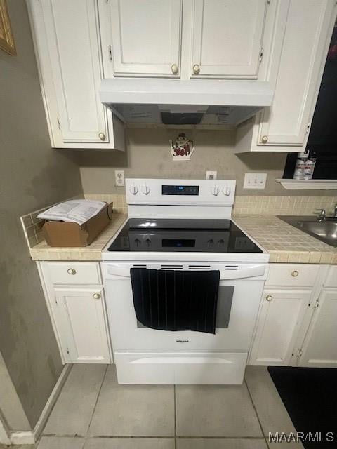 3440 Wickham Rd, Montgomery, AL 36116 - kitchen featuring white electric range oven, under cabinet range hood, white cabinetry, and light tile patterned flooring