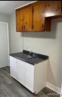 713 W Patton Ave, Montgomery, AL 36105 - kitchen with dark countertops, wood finished floors, and white cabinets