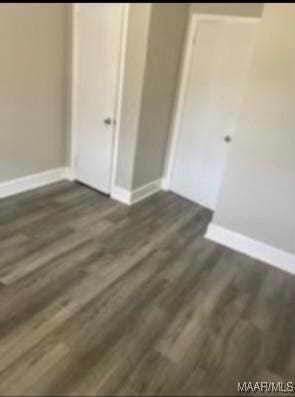 713 W Patton Ave, Montgomery, AL 36105 - unfurnished bedroom featuring baseboards and dark wood-type flooring