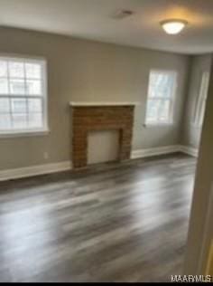 713 W Patton Ave, Montgomery, AL 36105 - unfurnished living room featuring healthy amount of natural light, a brick fireplace, and wood finished floors
