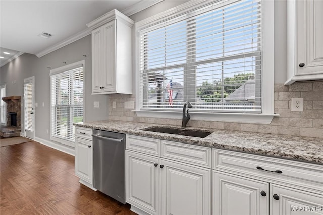 59 Gresham Dr, Millbrook, AL 36054 - kitchen featuring dishwasher, ornamental molding, a stone fireplace, tasteful backsplash, and white cabinetry