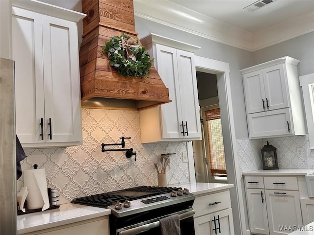 447 Cloverdale Rd, Greenville, AL 36037 - kitchen featuring stainless steel gas range, tasteful backsplash, light countertops, white cabinets, and crown molding