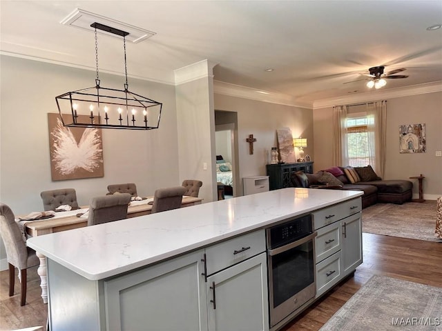 447 Cloverdale Rd, Greenville, AL 36037 - kitchen featuring open floor plan, oven, crown molding, dark wood-style floors, and gray cabinets