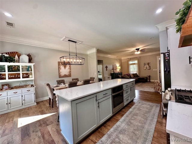447 Cloverdale Rd, Greenville, AL 36037 - kitchen with stainless steel appliances, gray cabinetry, open floor plan, ornamental molding, and a kitchen island