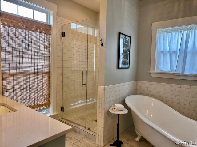 447 Cloverdale Rd, Greenville, AL 36037 - bathroom featuring a shower stall, a freestanding bath, marble finish flooring, vanity, and tile walls