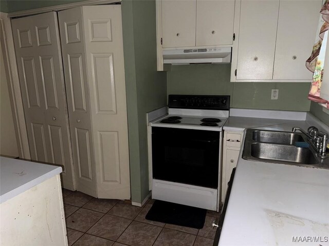 6119 Hinchcliff Rd, Montgomery, AL 36117 - kitchen with under cabinet range hood, range with electric cooktop, white cabinets, and tile patterned floors