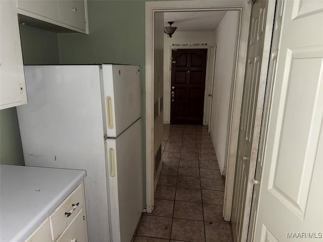 6119 Hinchcliff Rd, Montgomery, AL 36117 - kitchen with freestanding refrigerator, tile patterned floors, white cabinets, and light countertops