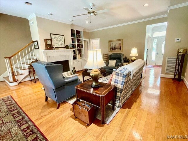 9865 Wynchase Cir, Montgomery, AL 36117 - living area featuring stairway, light wood-style floors, ceiling fan, ornamental molding, and a tiled fireplace