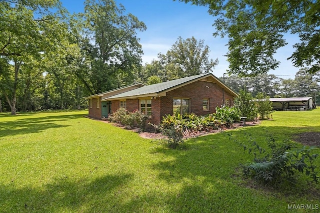 445 W Hickory Grove Rd, Lapine, AL 36046 - view of home's exterior with a lawn, brick siding, and a metal roof