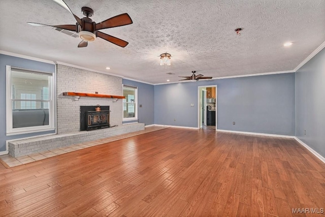 445 W Hickory Grove Rd, Lapine, AL 36046 - unfurnished living room with ceiling fan, wood finished floors, crown molding, a textured ceiling, and a wood stove