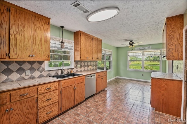 445 W Hickory Grove Rd, Lapine, AL 36046 - kitchen featuring stainless steel dishwasher, tile counters, brick patterned flooring, decorative backsplash, and ceiling fan