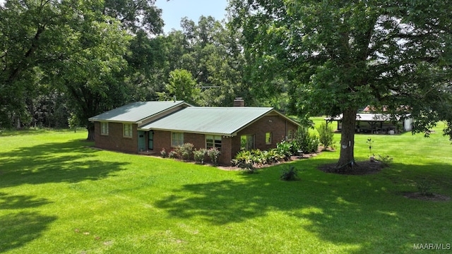 445 W Hickory Grove Rd, Lapine, AL 36046 - view of front of home featuring a chimney, a front yard, brick siding, and a metal roof