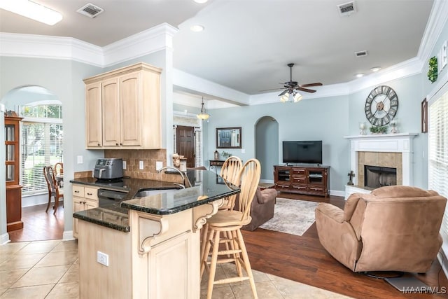 204 Village Way, Wetumpka, AL 36093 - kitchen with arched walkways, a peninsula, a breakfast bar, plenty of natural light, and crown molding