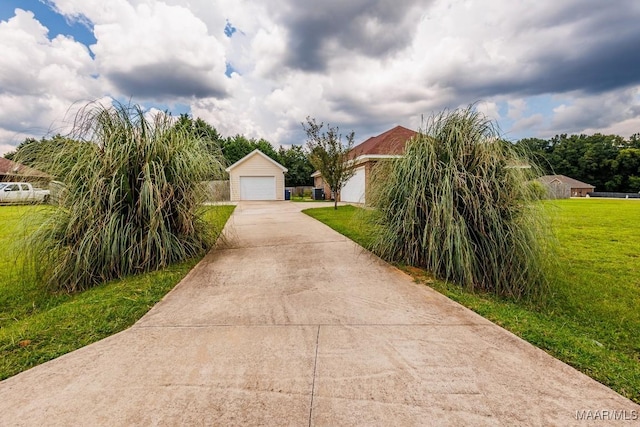 205 Jennifer Ln, Deatsville, AL 36022 - view of property hidden behind natural elements with a detached garage, a front yard, an outbuilding, and concrete driveway
