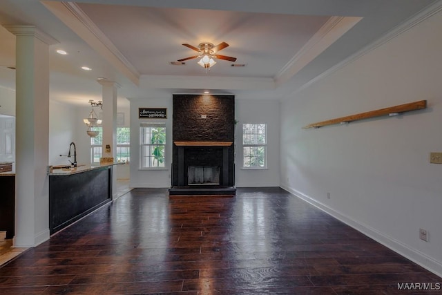 205 Jennifer Ln, Deatsville, AL 36022 - unfurnished living room featuring dark wood-style flooring, a raised ceiling, ornate columns, a ceiling fan, and ornamental molding