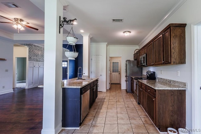 205 Jennifer Ln, Deatsville, AL 36022 - kitchen with stainless steel appliances, dark brown cabinets, light stone counters, and ornamental molding
