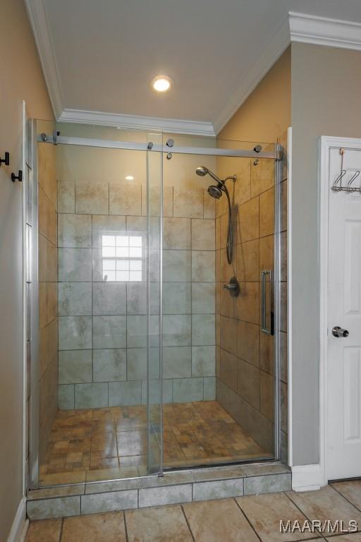 205 Jennifer Ln, Deatsville, AL 36022 - bathroom featuring ornamental molding, tile patterned flooring, and a stall shower