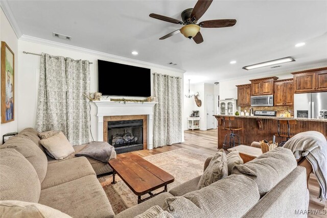 447 Galloway Dr, Wetumpka, AL 36093 - living area featuring ornamental molding, a ceiling fan, light wood-style flooring, a tiled fireplace, and recessed lighting
