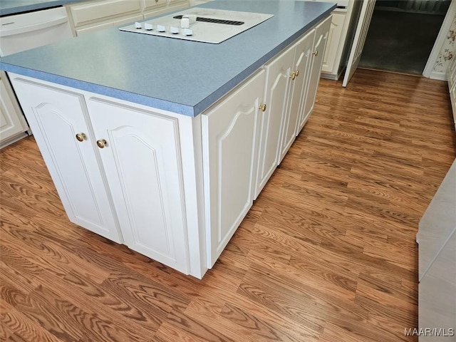 2714 Luverne Hwy, Greenville, AL 36037 - kitchen featuring stovetop with downdraft, white cabinets, a center island, and light wood-style floors