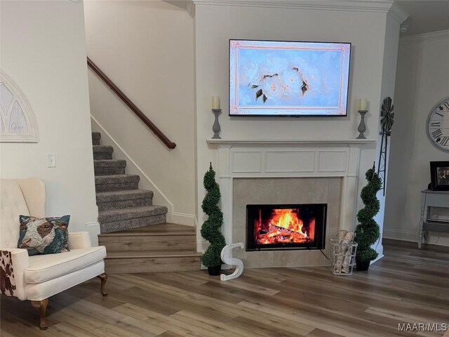 178 Natures Trl, Wetumpka, AL 36093 - living room with stairs, wood finished floors, a tiled fireplace, and ornamental molding