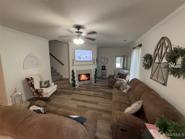178 Natures Trl, Wetumpka, AL 36093 - living area with a warm lit fireplace, wood finished floors, ceiling fan, crown molding, and stairs
