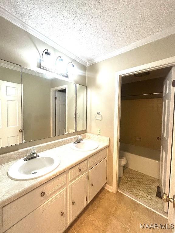 2 Rolling Hills Cir, Camden, AL 36726 - bathroom with crown molding, double vanity, a textured ceiling, a bathtub, and tile patterned floors