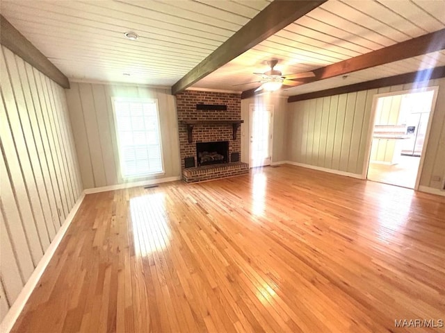 2 Rolling Hills Cir, Camden, AL 36726 - unfurnished living room featuring light wood finished floors, a brick fireplace, a wooden ceiling with exposed beams, ceiling fan, and wood walls