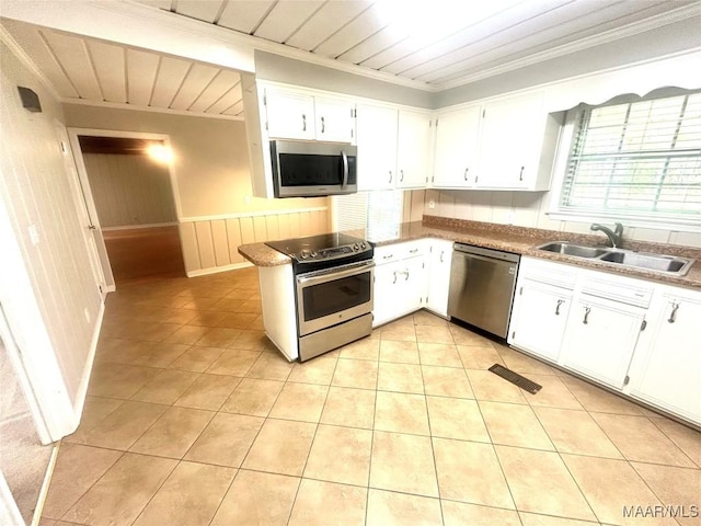 2 Rolling Hills Cir, Camden, AL 36726 - kitchen with appliances with stainless steel finishes, ornamental molding, white cabinetry, light tile patterned flooring, and wainscoting