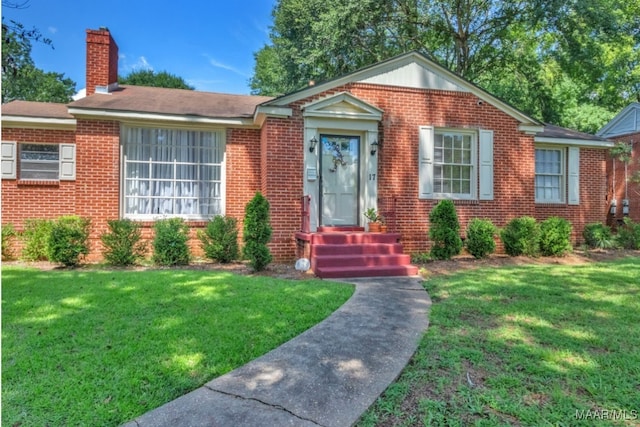 17 Calhoun Rd, Montgomery, AL 36109 - view of front of home with brick siding, a front yard, and a chimney
